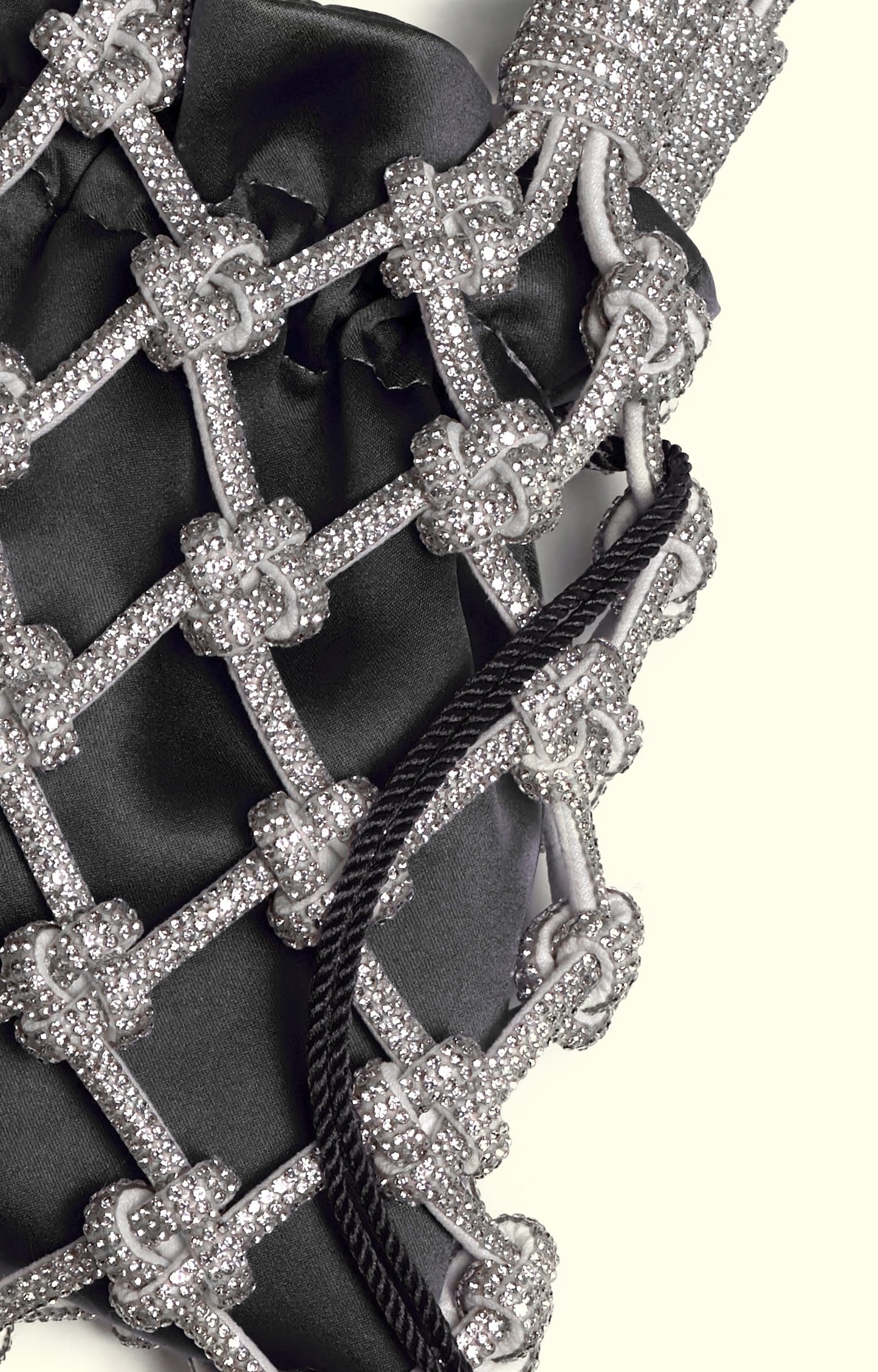 Black satin drawstring pouch inside a rhinestone net bag