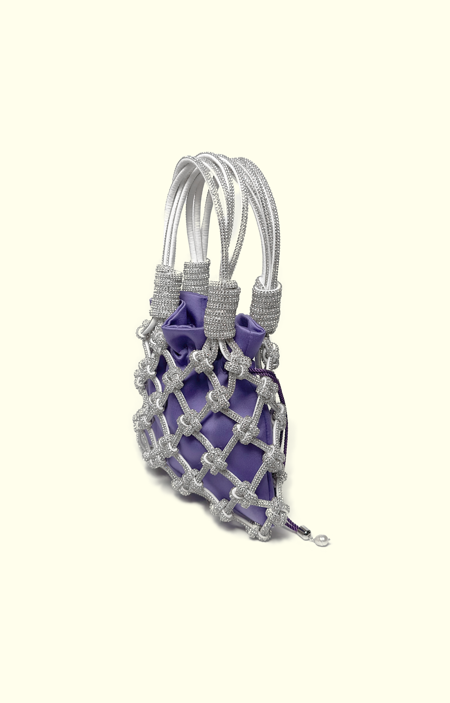 Purple satin drawstring pouch inside a rhinestone net bag
