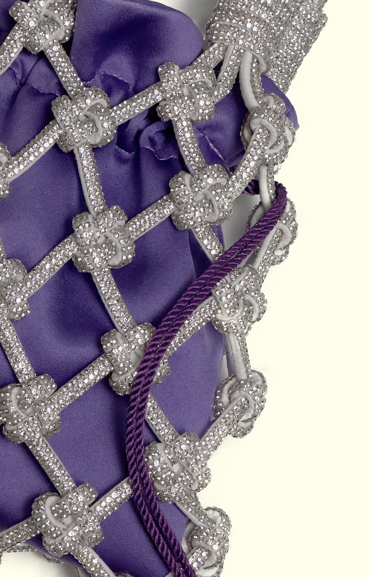 Purple satin drawstring pouch inside a rhinestone net bag