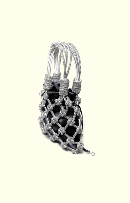 Black satin drawstring pouch inside a rhinestone net bag