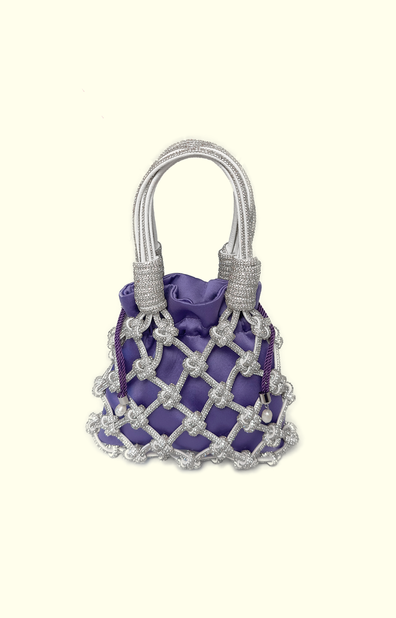 Purple satin drawstring pouch inside a rhinestone net bag