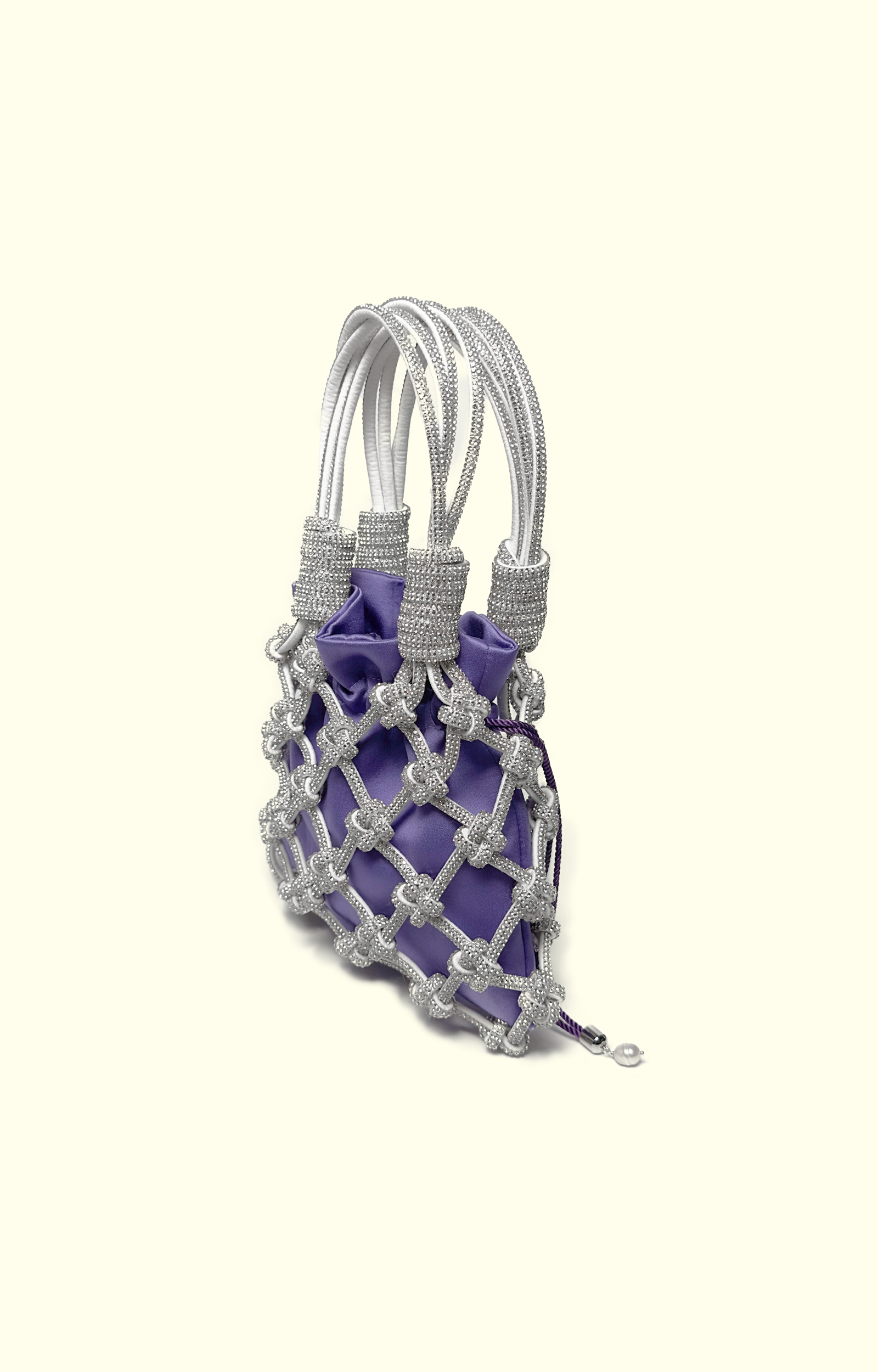 Purple satin drawstring pouch inside a rhinestone net bag