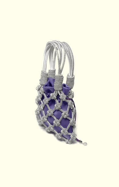 Purple satin drawstring pouch inside a rhinestone net bag