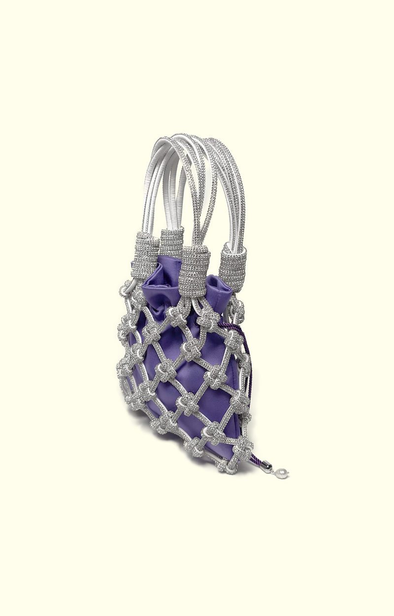 Purple satin drawstring pouch inside a rhinestone net bag