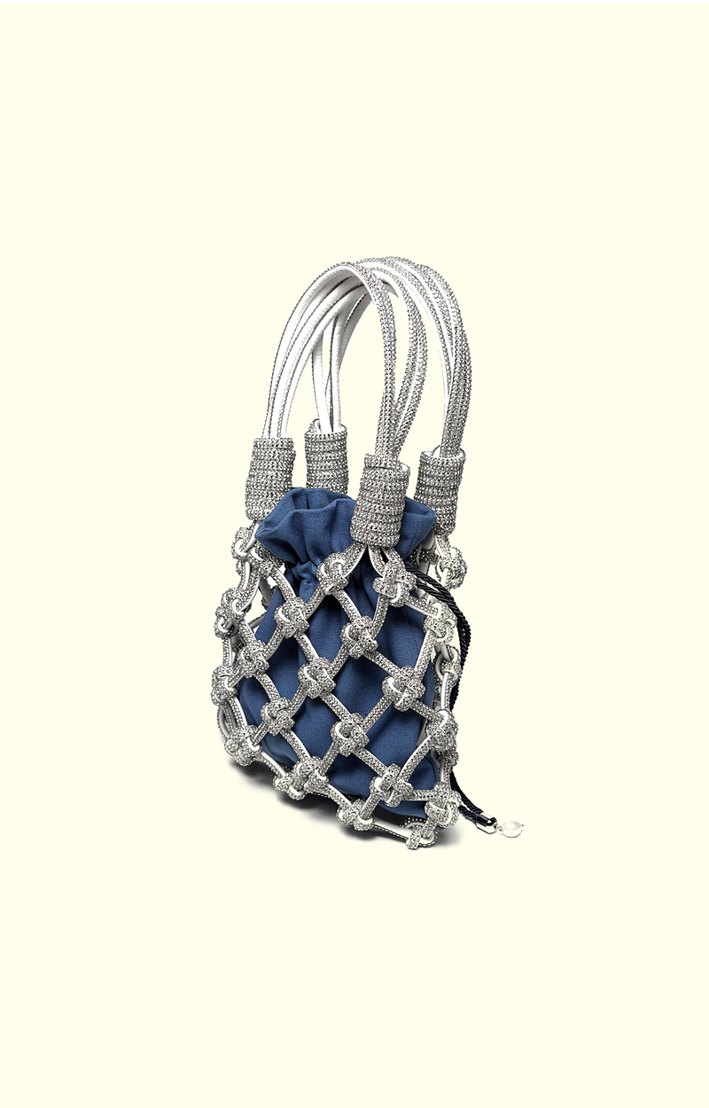 Blue denim drawstring pouch inside a rhinestone net bag
