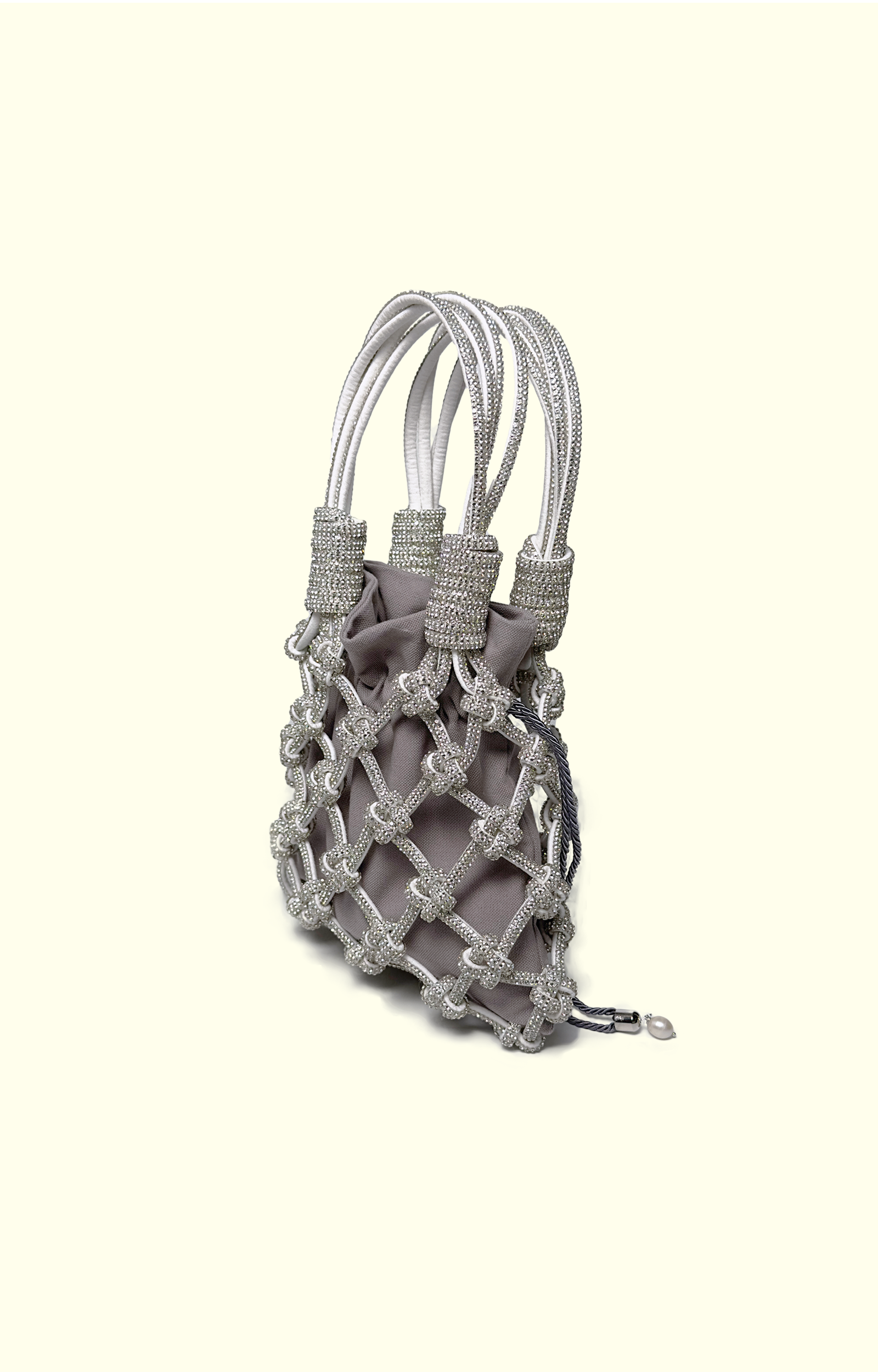 Grey drawstring pouch inside a rhinestone net bag