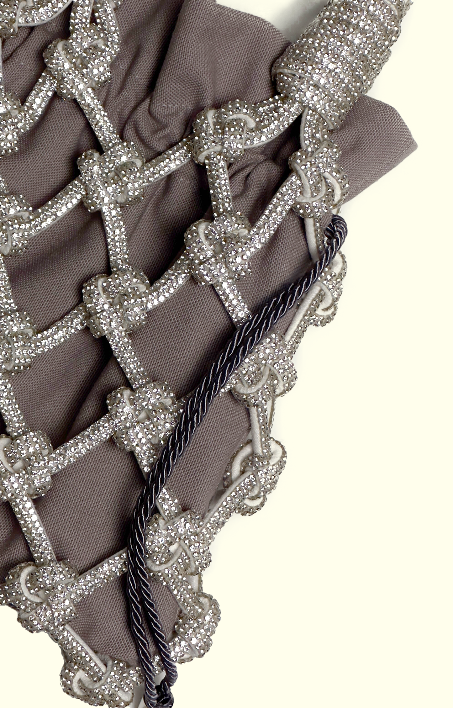 Grey drawstring pouch inside a rhinestone net bag