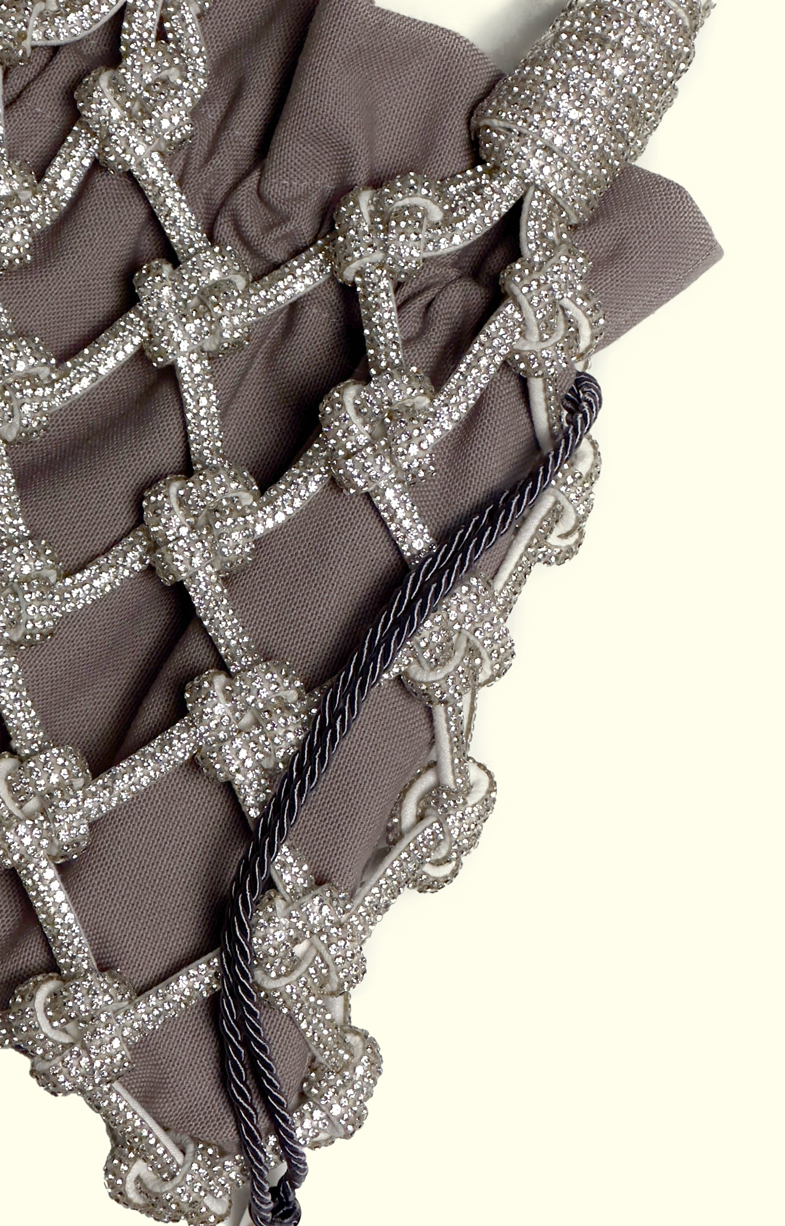 Grey drawstring pouch inside a rhinestone net bag
