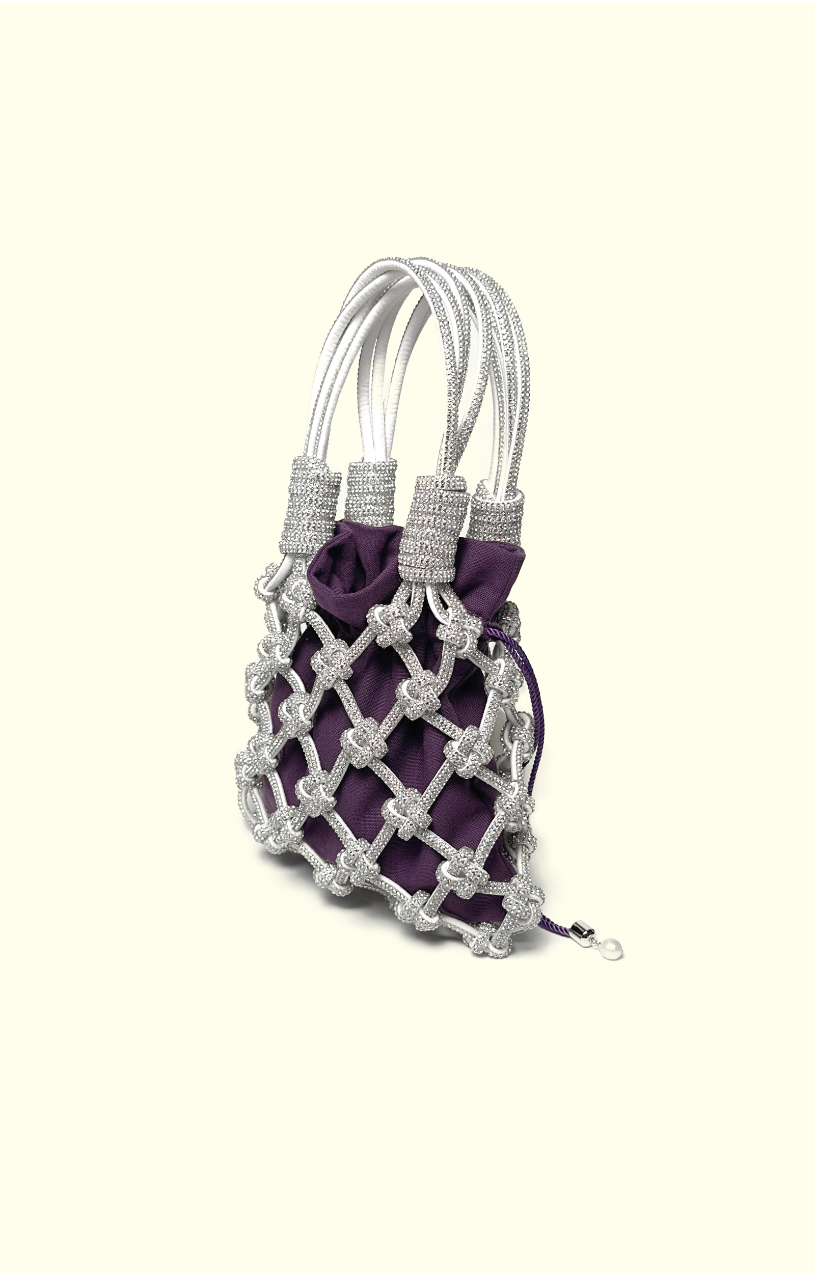 Purple cotton drawstring pouch inside a rhinestone net bag
