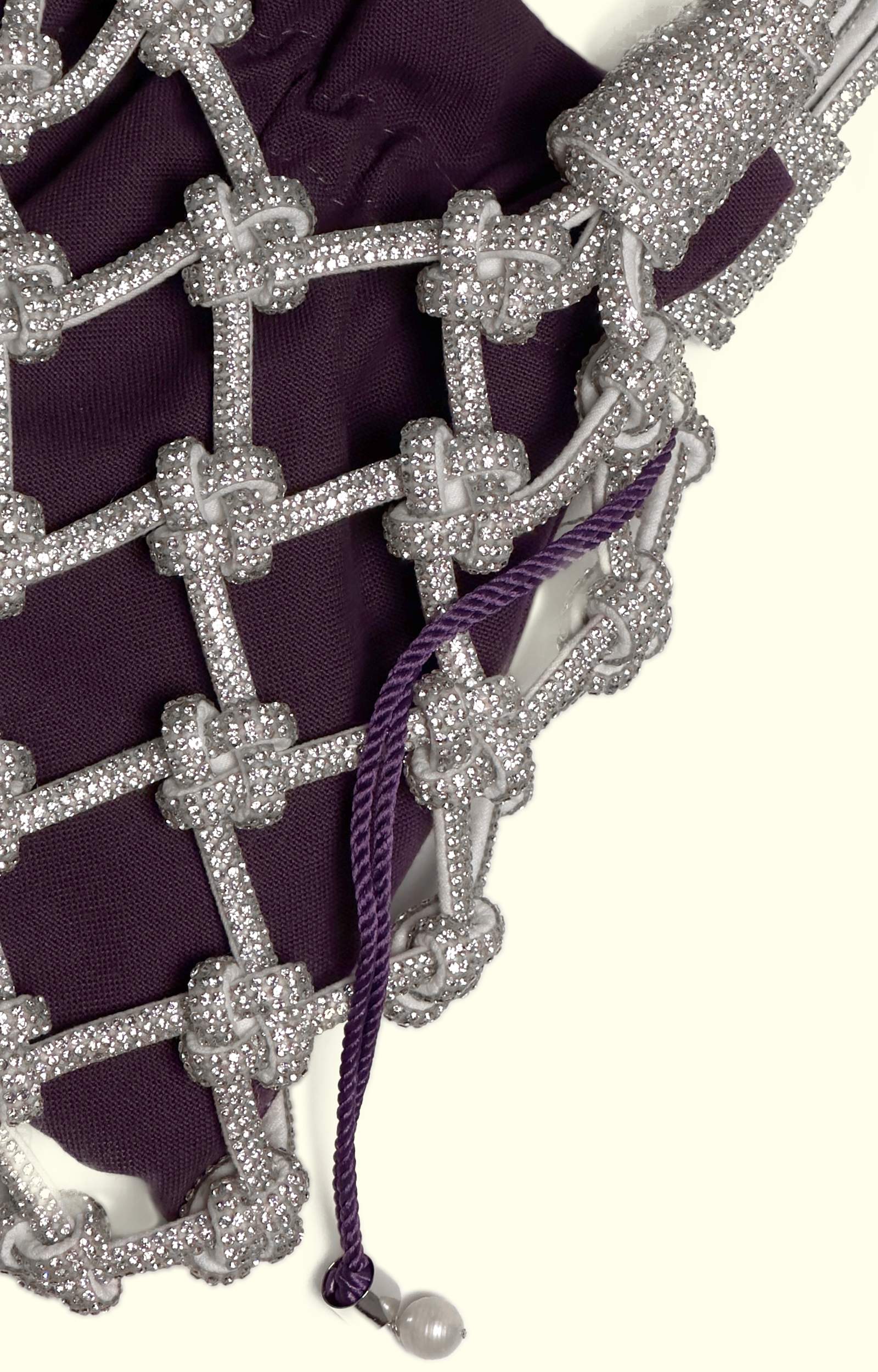Purple cotton drawstring pouch inside a rhinestone net bag