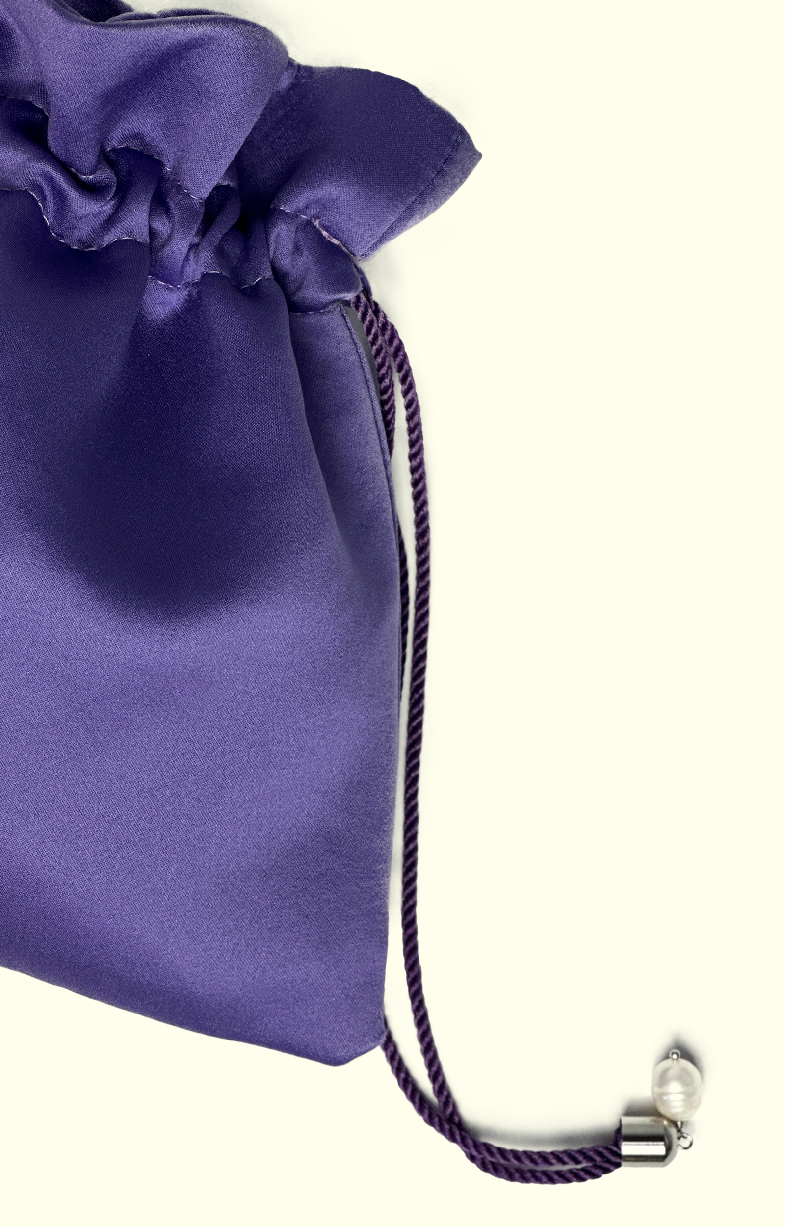 Purple drawstring bag with a silver clasp on a white background